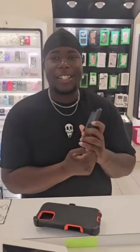 A CELLTECH customer holding his repaired phone at the store counter