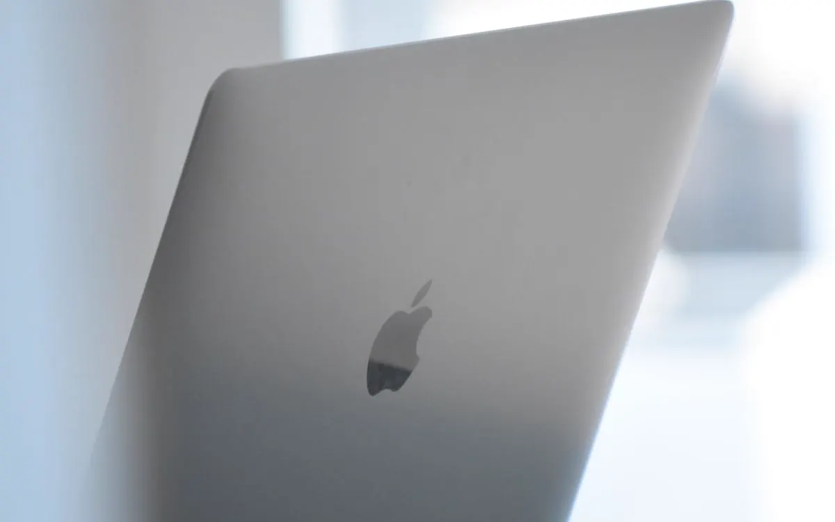 A silver MacBook open on a desk