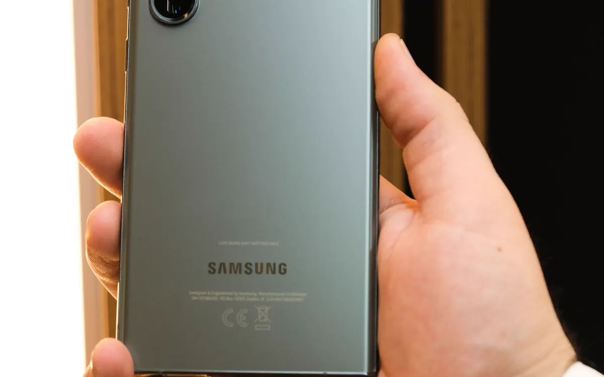 A hand holding a Samsung Galaxy S23 Ultra, its rear cameras in view