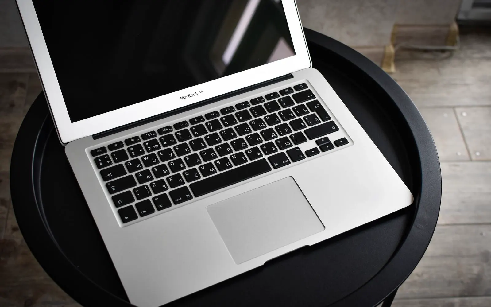 An open MacBook Air on a small black table