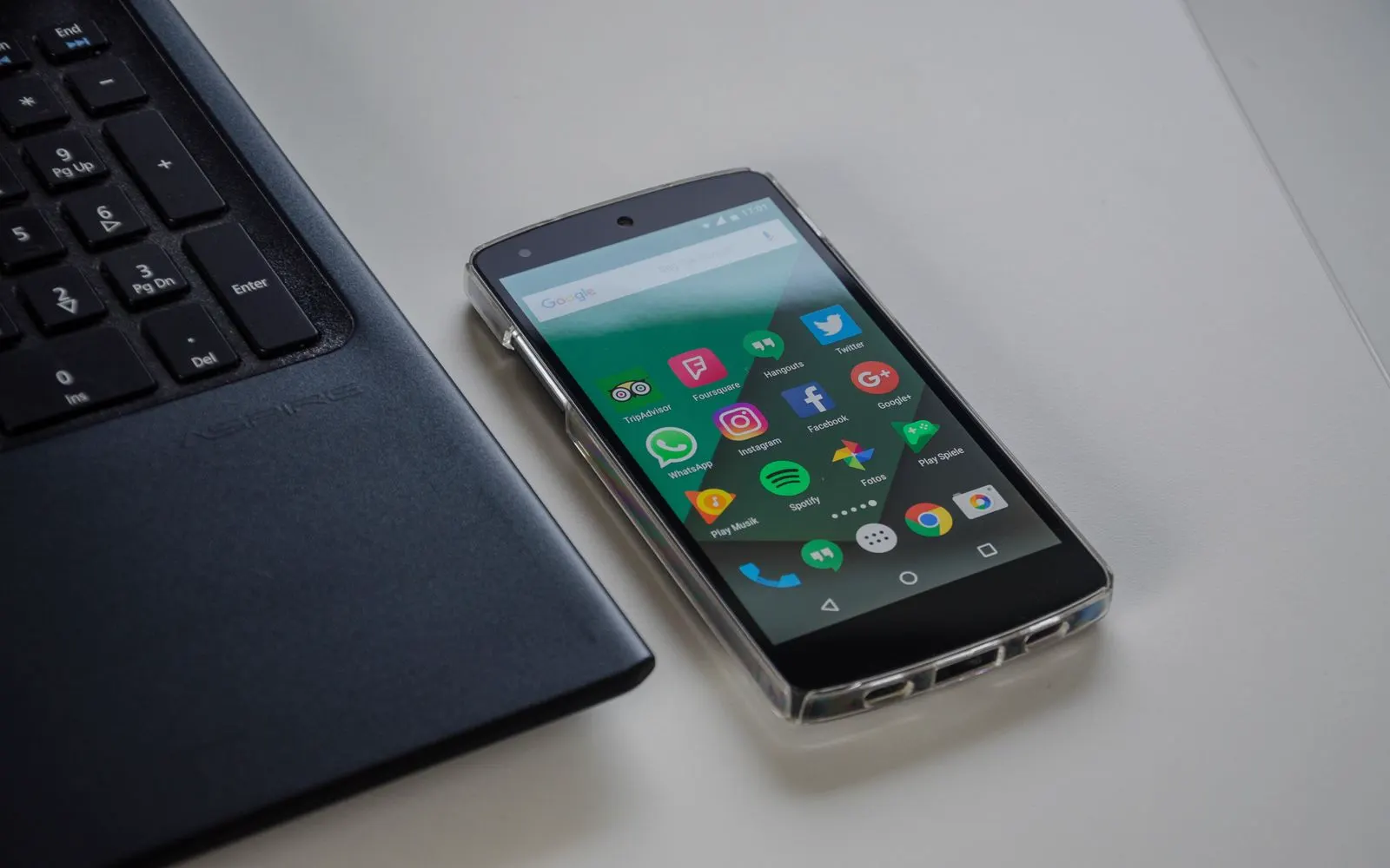 A phone resting on a table beside a laptop