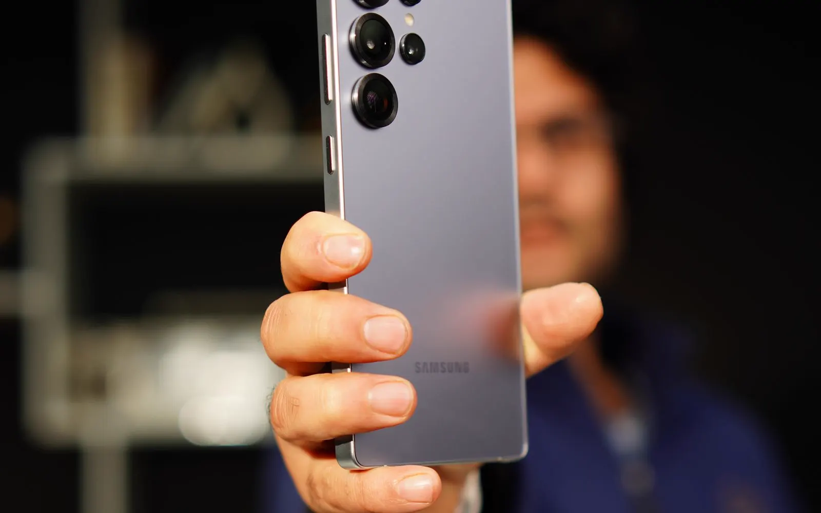 A person holding a Samsung Galaxy phone indoors
