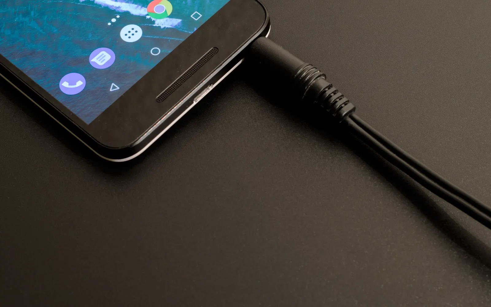 A close-up of a phone connected to its charging cable