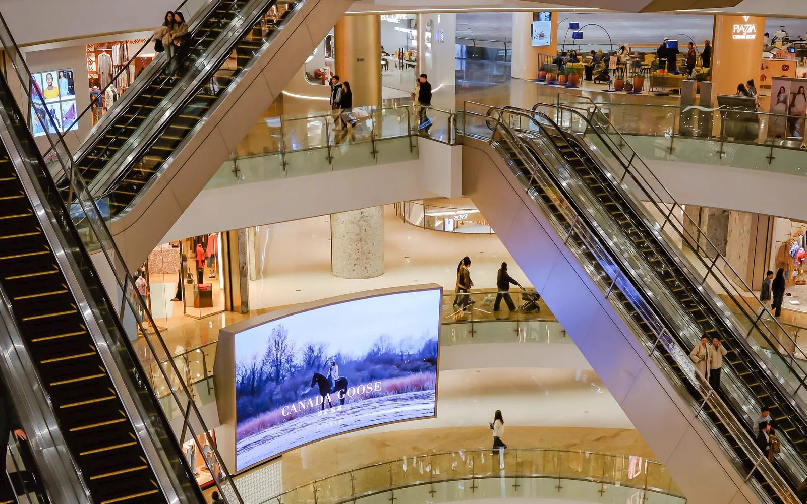 Shoppers on the escalators of a busy multi level shopping mall