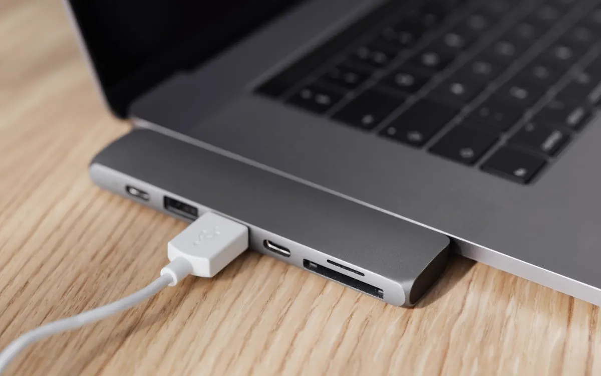 A laptop connected to a USB-C adapter with a charging cable plugged in