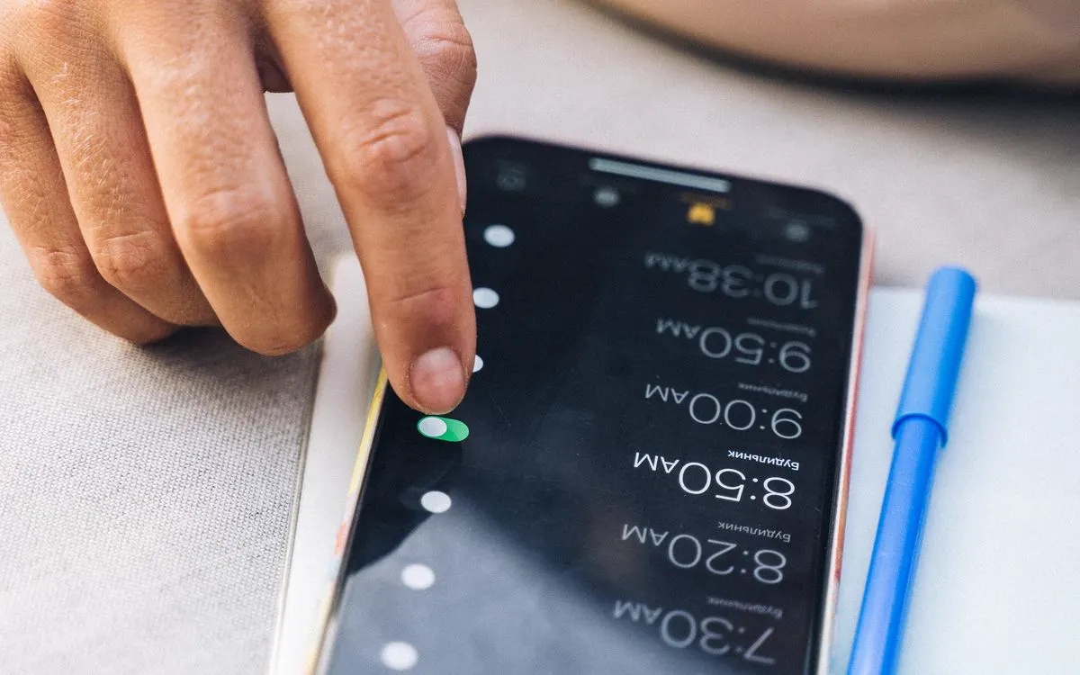 A hand checking settings on a smartphone screen