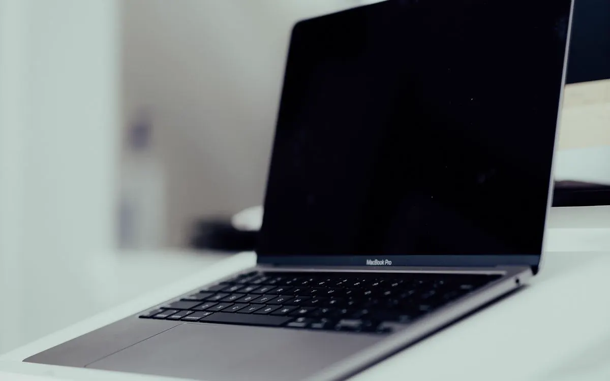 An open MacBook Pro on a clean white desk