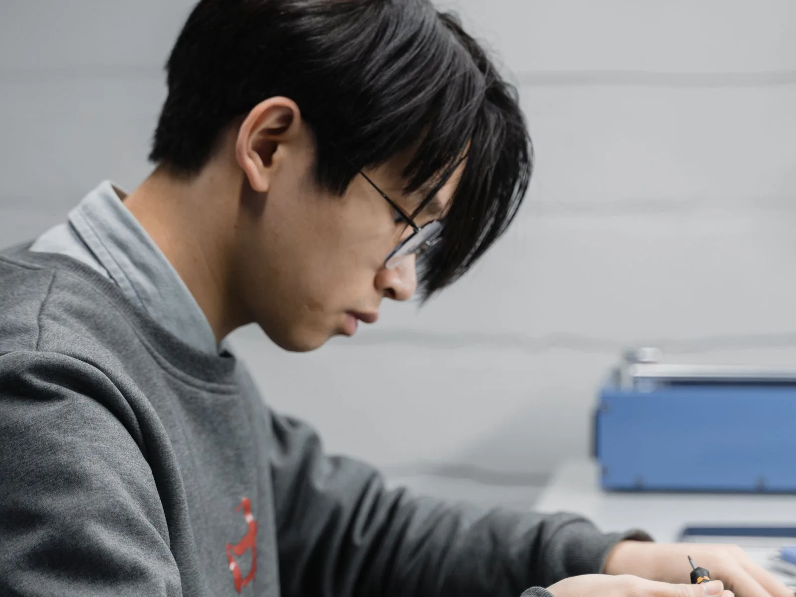 A CELLTECH technician working on a phone at a repair bench