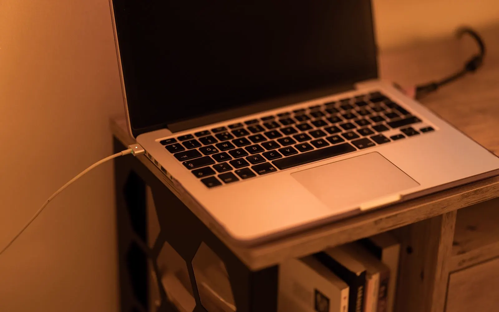 An open laptop on a wooden desk in warm light