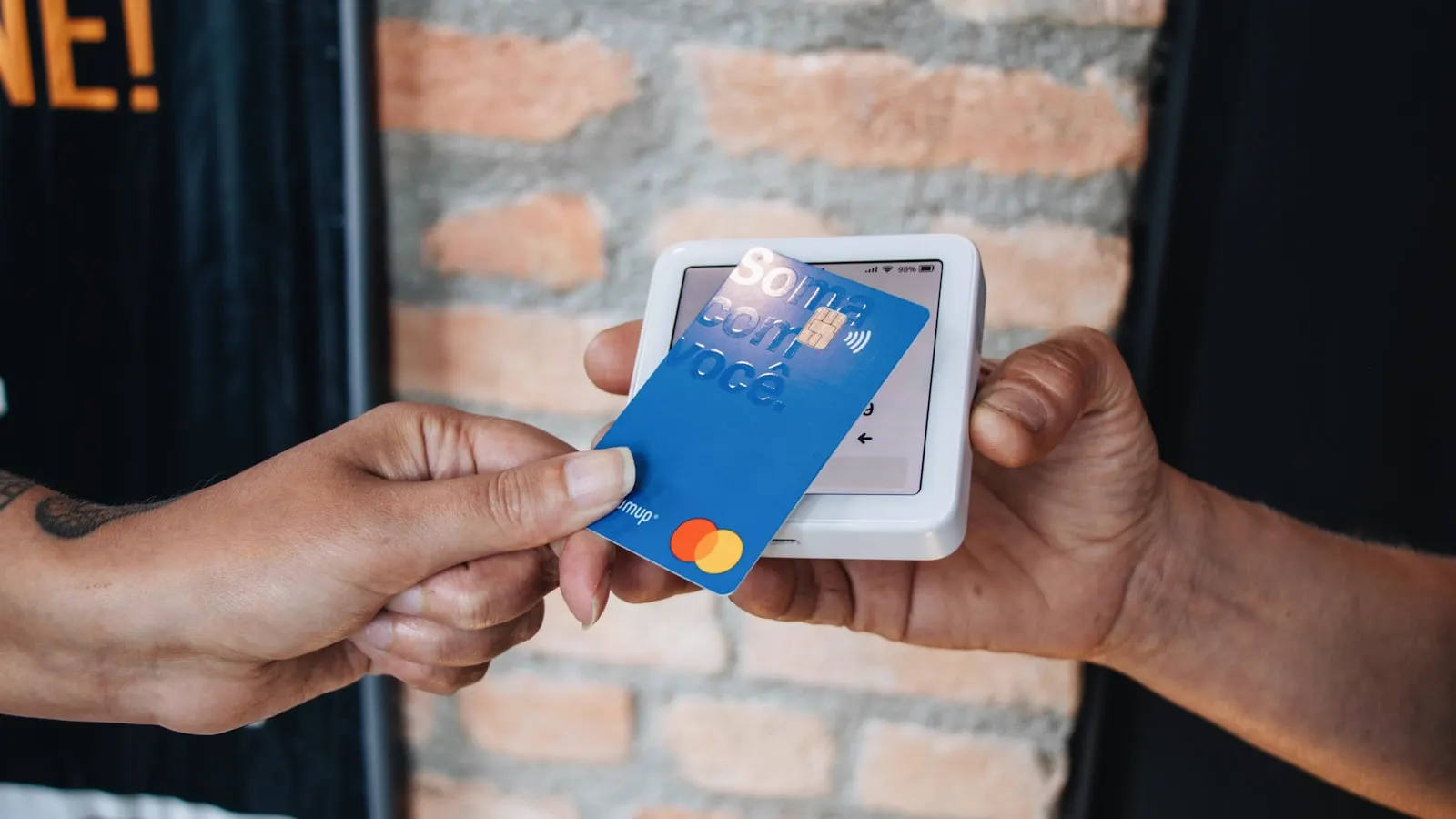 A person handing a card to another person across a counter